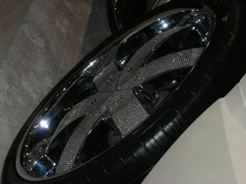 1998 Ford Crown Victoria - chrome wheel whose spinner-style spokes are densely covered in rhinestones, mounted on a low-profile tire.