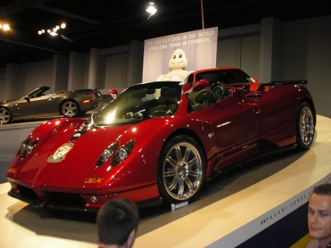 1998 Ford Crown Victoria - Red sports car on display with a Michelin Man and banner in the background.