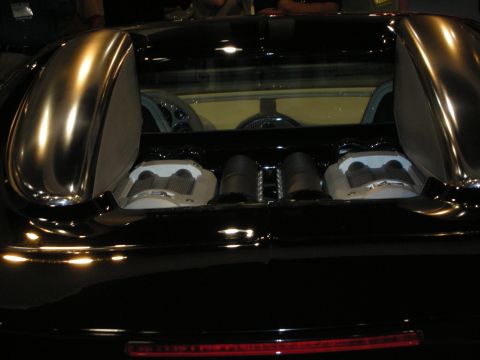 1998 Ford Crown Victoria - The rear of a black Bugatti Veyron reveals its powerful W16 engine configuration.