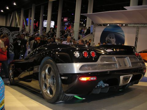 1998 Ford Crown Victoria - Rear view of a black sports car with distinctive quad taillights and a large alloy wheel on display.