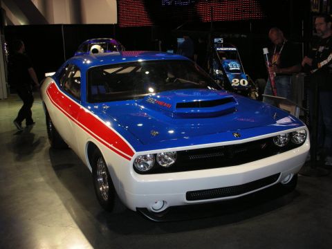 1998 Ford Crown Victoria - patriotic red, white and blue Dodge Challenger with a 392 HEMI hood scoop sits on display at an indoor automotive show.
