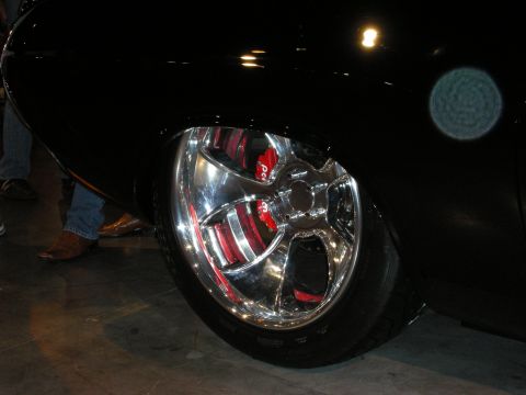 1998 Ford Crown Victoria - polished five-spoke wheel with a red drilled brake caliper sits under the fender of a glossy black show car.