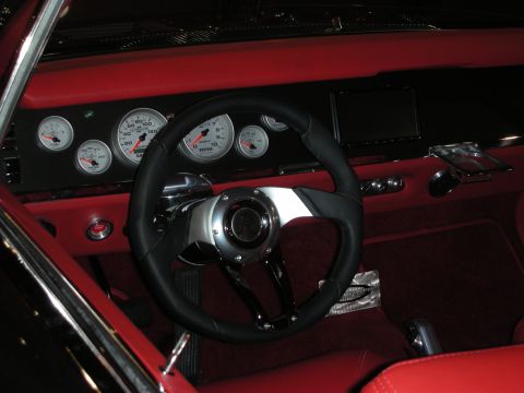 1998 Ford Crown Victoria - custom interior with bright red leather, a cluster of white-faced gauges and a black three-spoke steering wheel.