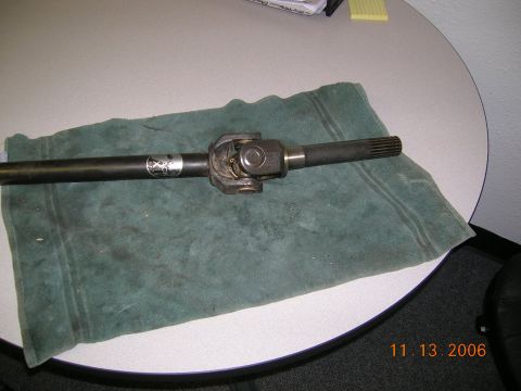 1985 Ford Bronco - A close-up of a vehicle's driveshaft component, showing the universal joint and splined connection.