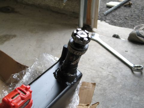 1995 Ford Bronco - A close-up view of an automotive part with a castle nut, alongside a large wrench.
