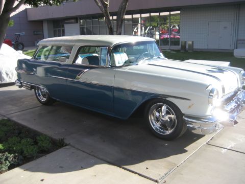 1998 Ford Crown Victoria - This two-tone blue and white station wagon, likely a 1955 model, is shown from the front three-quarter view.