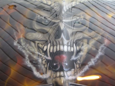 1998 Ford Crown Victoria - Custom airbrush art depicts a skull with flames and smoke, likely on a vehicle part.