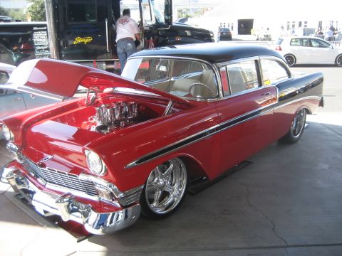 1998 Ford Crown Victoria - Customized 1956 Chevrolet Bel Air with a V8 engine and chrome wheels is displayed outdoors.