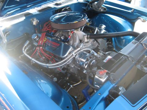 1998 Ford Crown Victoria - Close-up view of a custom engine bay with polished components and bright blue paint.