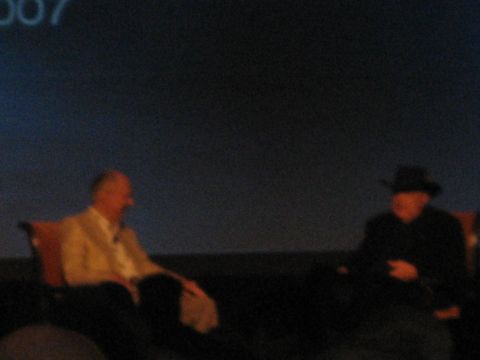 1998 Ford Crown Victoria - Two men are seated in chairs, with the number "007" displayed on a screen behind them.