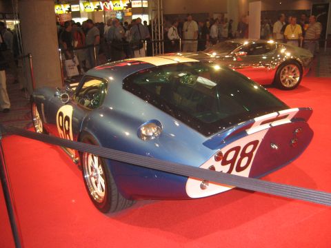1998 Ford Crown Victoria - A blue and white racing car with the number 98 is displayed on a red carpet, with another car in the background.