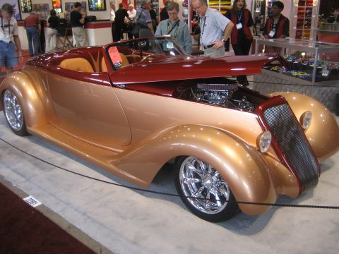 1998 Ford Crown Victoria - A custom hot rod convertible with a two-tone paint job and exposed engine is on display.