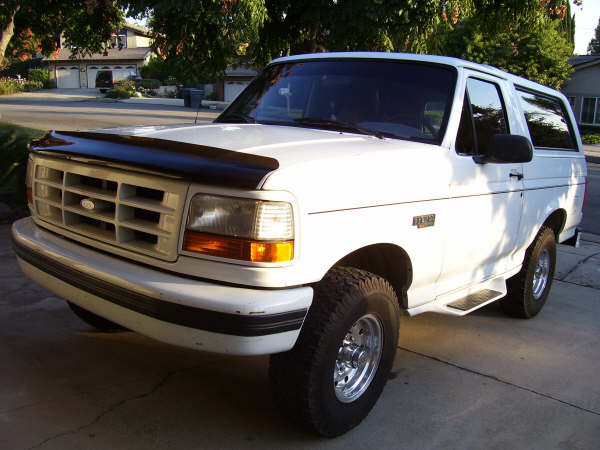 White Ford Bronco with a black bug deflector, parked on a driveway
