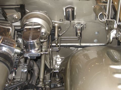 1998 Ford Crown Victoria - Close-up view of chrome-finished brake system components in a vehicle's engine bay.