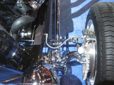 1998 Ford Crown Victoria - Detailed view of a vehicle's suspension system, polished chrome components and a tire.