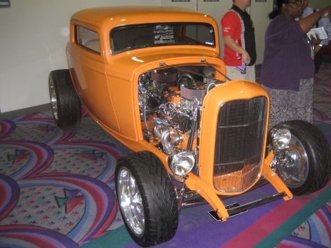 1998 Ford Crown Victoria - This custom orange hot rod features a highly detailed, exposed engine and chrome wheels, displayed indoors.