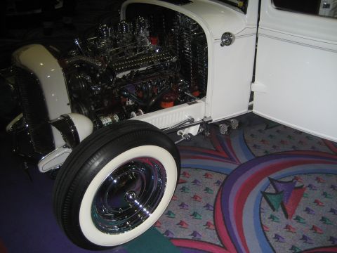 1998 Ford Crown Victoria - A custom hot rod displays its powerful chrome engine and open door, parked on a patterned carpet.