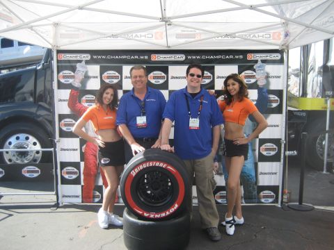 1998 Ford Crown Victoria - A group poses with tires at a racing event, with a black truck and a Volvo visible in the background.