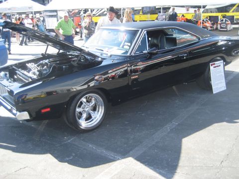 1998 Ford Crown Victoria - Black 1970 Dodge Charger R/T with hood open, displayed at an outdoor event.