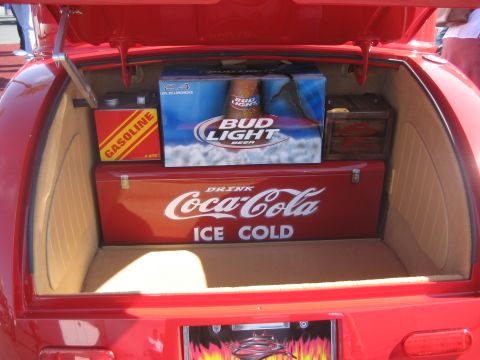 1998 Ford Crown Victoria - The trunk of a red car is filled with a Coca-Cola cooler, a case of Bud Light beer, and a red gasoline can.