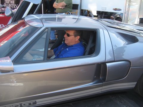 1998 Ford Crown Victoria - Man in sunglasses sits in a silver Ford GT sports car.