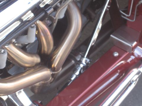 1998 Ford Crown Victoria - Detail of a vehicle's engine, focusing on the exhaust manifold and chrome components.
