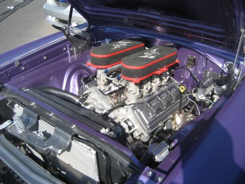 1998 Ford Crown Victoria - Close-up of a modified V8 engine with twin air intakes and custom purple paint.