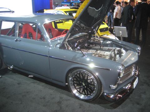1998 Ford Crown Victoria - A modified Volvo P1800 ES wagon is displayed with its hood open, revealing the engine and custom interior.