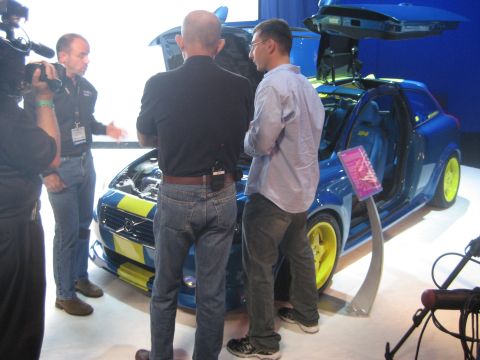 1998 Ford Crown Victoria - People examine a blue Volvo C30 with its gullwing doors open at an auto show.