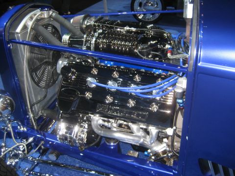 1998 Ford Crown Victoria - Custom engine bay features a polished supercharger and chrome exhaust components on a bright blue hot rod.