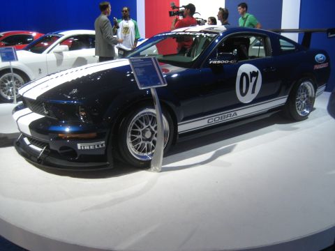1998 Ford Crown Victoria - A dark blue Ford Mustang Shelby GT500 is displayed with other vehicles at an auto show.