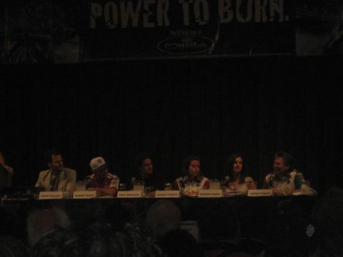 1998 Ford Crown Victoria - A group of people are seated at a table with name tags, with a banner overhead that says "POWER TO BURN."