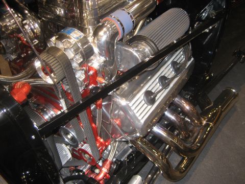 1998 Ford Crown Victoria - Close-up view of a highly customized engine bay with polished metal components and bright red accents.