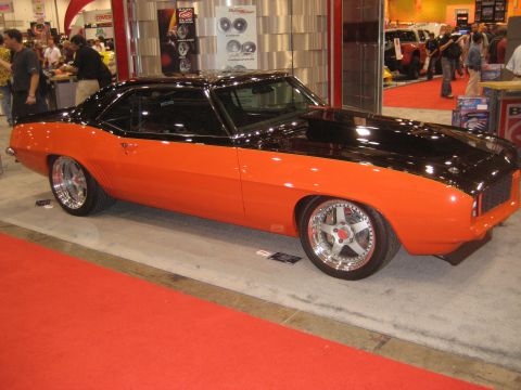 1998 Ford Crown Victoria - This classic muscle car is displayed indoors on a red carpet with a black hood and custom rims.