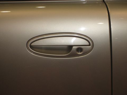 1998 Ford Crown Victoria - Detail of a car's door handle and surrounding body panel.