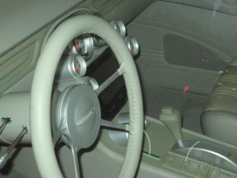 1998 Ford Crown Victoria - The interior of a car shows a custom steering wheel and multiple gauges, indicating aftermarket modifications.