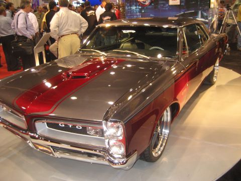 1998 Ford Crown Victoria - This 1966 Pontiac GTO features a distinctive dual-stripe paint scheme and prominent GTO badging.