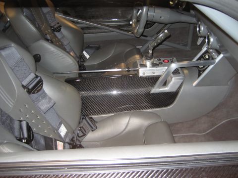 1998 Ford Crown Victoria - The interior of a car shows racing seats, a roll cage, and extensive carbon fiber detailing.