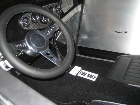 1998 Ford Crown Victoria - The interior of a car is shown with a "FOR SALE" sign placed on the black carpeted floor.