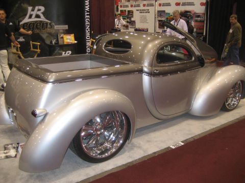 1998 Ford Crown Victoria - Custom hot rod pickup truck with a two-tone silver and gray finish and chrome wheels is displayed indoors.