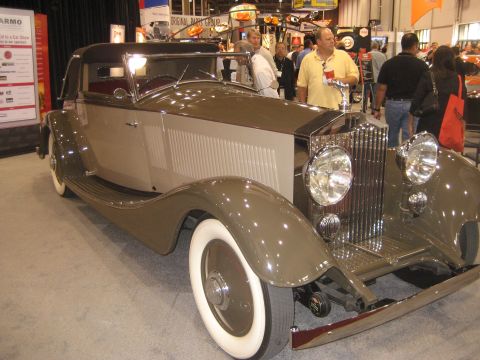 1998 Ford Crown Victoria - This vintage convertible car is on display indoors, possibly at a car show.