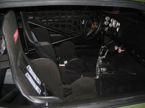 1998 Ford Crown Victoria - The interior of a modified vehicle features racing bucket seats, a roll cage, and a prominent TCI shifter, indicating a performance-oriente…