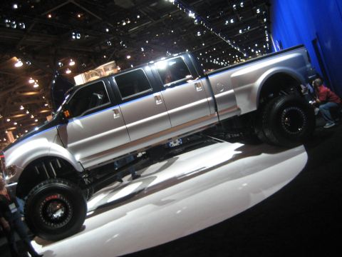1998 Ford Crown Victoria - This heavily modified pickup truck features an extended cab and dual rear wheels, presented at an indoor event.
