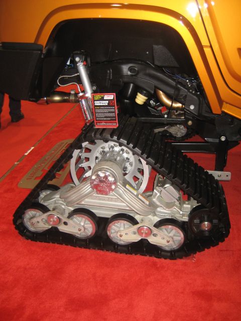1998 Ford Crown Victoria - An orange vehicle is shown with a track system and suspension components, suggesting off-road or specialized capability.