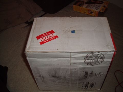 2006 Ford E350 - A cardboard box with 'Fragile' stickers and shipping labels is shown.