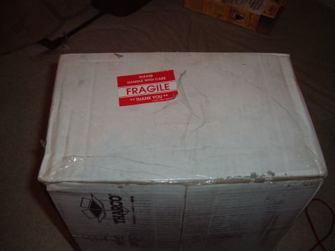 2006 Ford E350 - A white cardboard box is sealed with tape and features a prominent red fragile sticker.