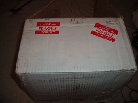 2006 Ford E350 - A closed cardboard box with 'FRAGILE' stickers is shown from a slightly elevated angle.