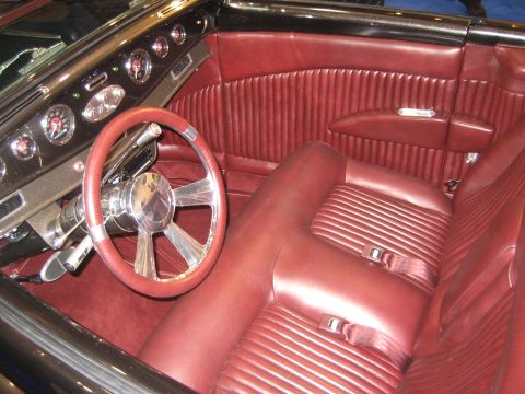1998 Ford Crown Victoria - The plush red interior features a custom steering wheel and a dashboard with multiple gauges.