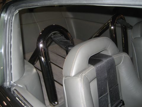 1998 Ford Crown Victoria - The interior of a car features a roll cage and gray leather seats with prominent stitching.
