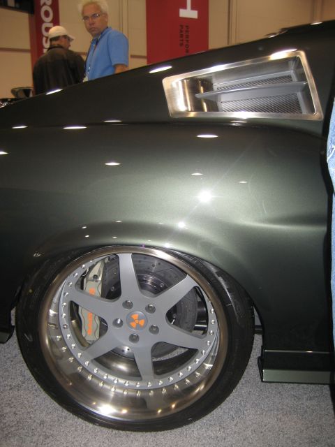 1998 Ford Crown Victoria - Close-up of a customized classic car's rear wheel and bodywork, showing aftermarket modifications.
